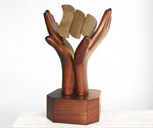Escultura de madera manos mutual seguridad